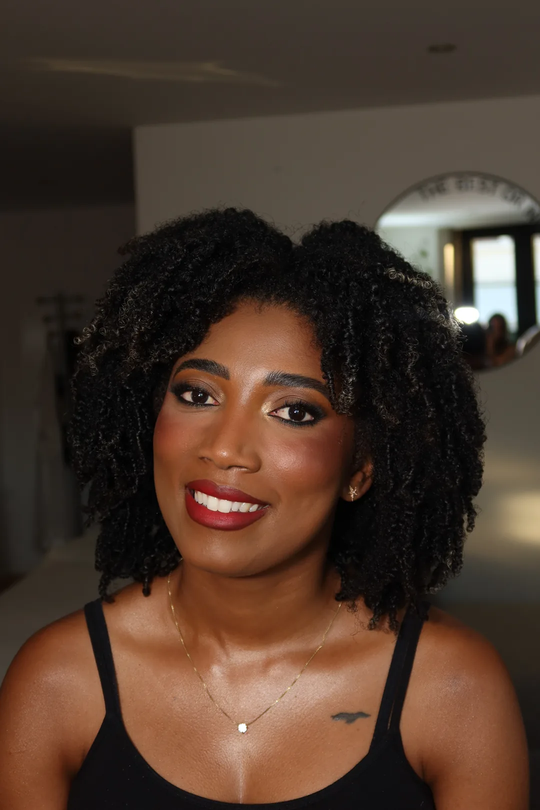 Natural curls, glowing warm skin, defined brows and a red lip