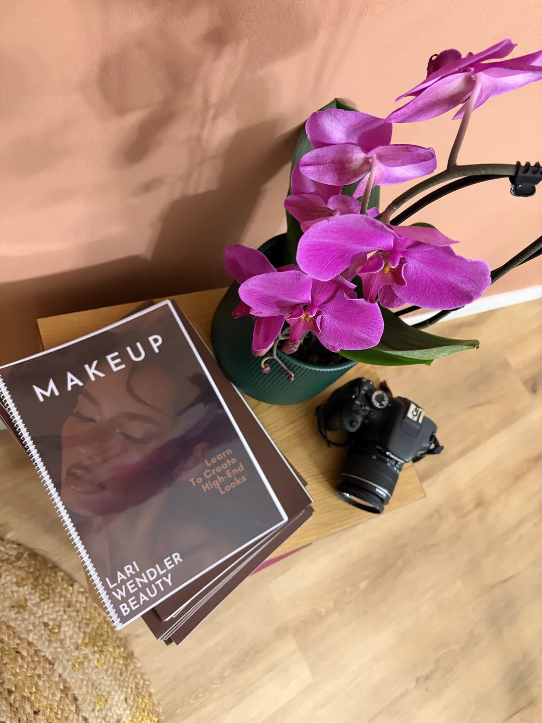 Lari Wendler Beauty visagism and makeup books on a studio table, next to an orchid