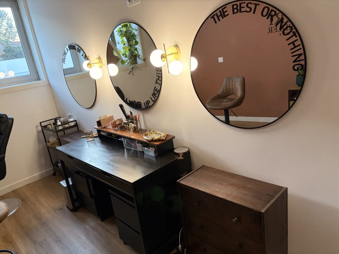 The Lari Wendler Beauty studio in Vila Nova de Gaia: round lit mirrors and the makeup counter