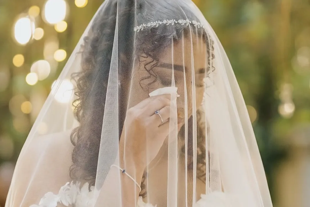 Noiva de véu na cerimónia, com a maquilhagem intacta