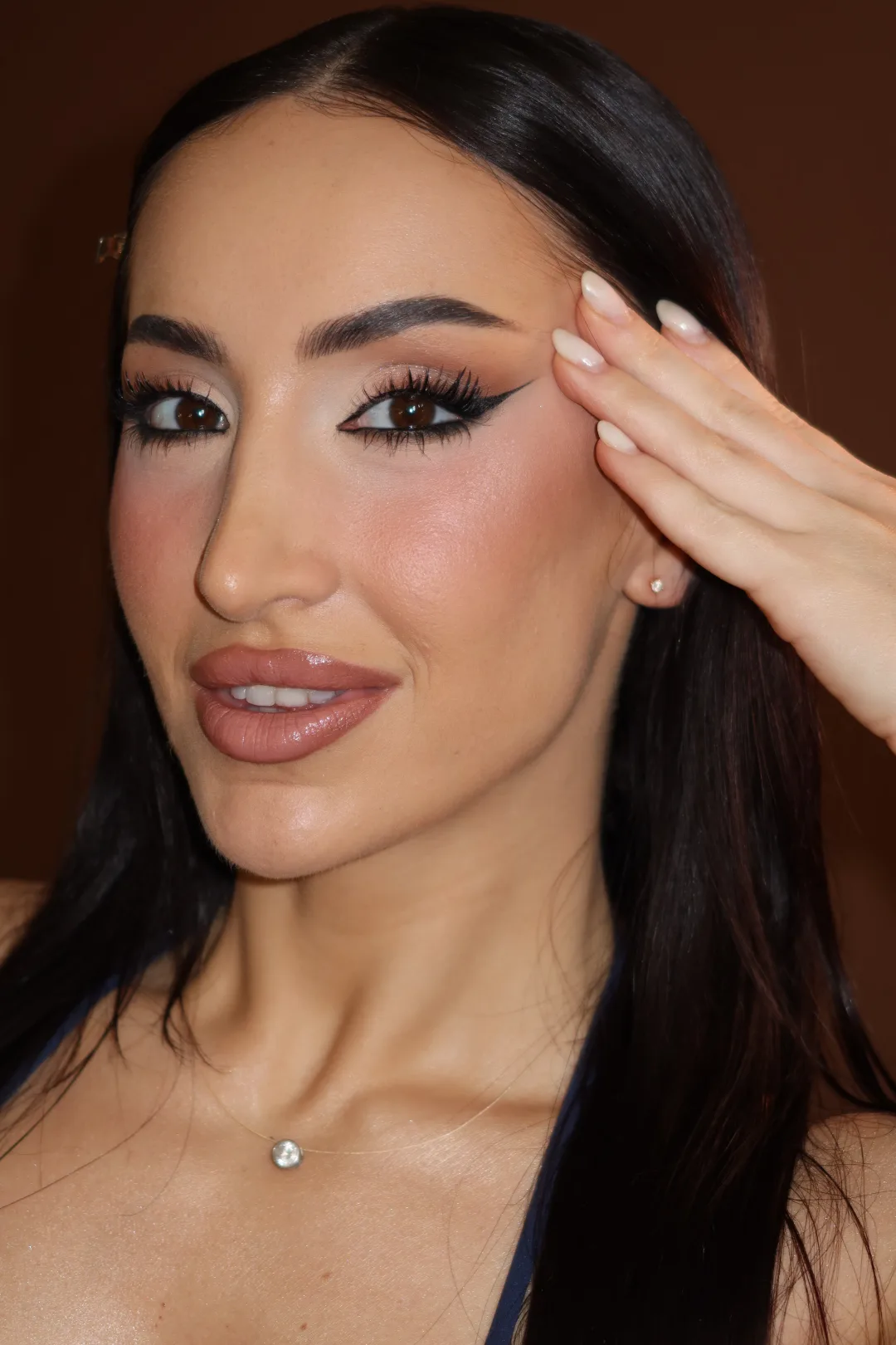 Maquilhagem profissional com eyeliner gráfico, pele luminosa e lábio nude, feita por Lari Wendler Beauty