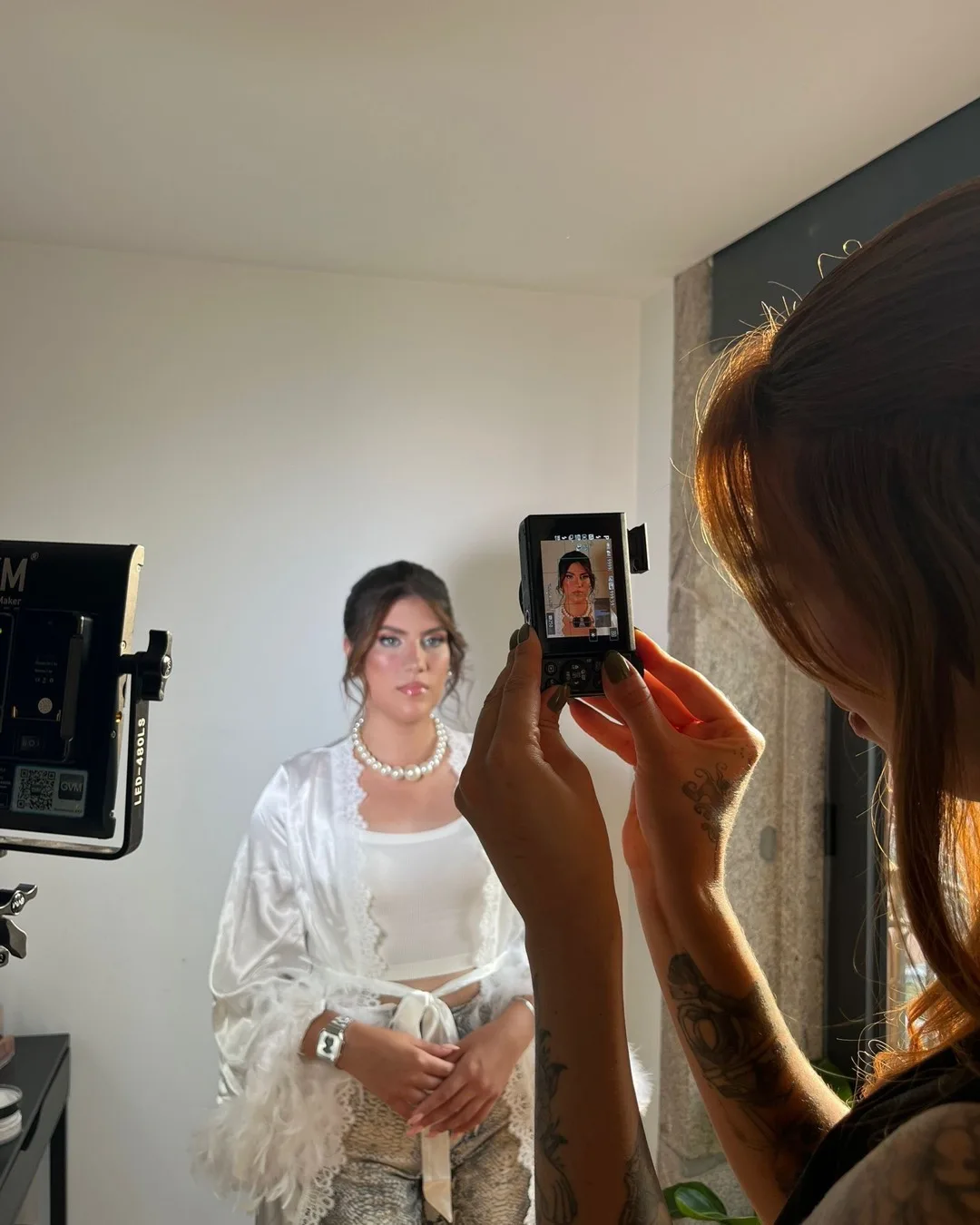 Noiva a ser fotografada ao espelho durante a prova de maquilhagem, no estúdio do Porto