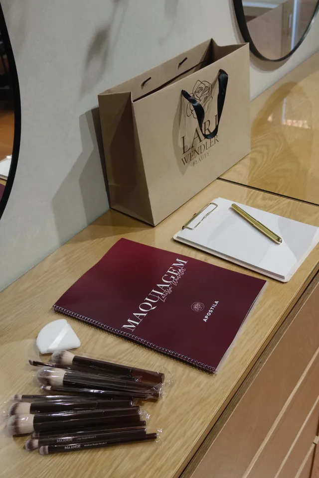 Materiais de formação: manual de maquilhagem, pincéis e saco da marca