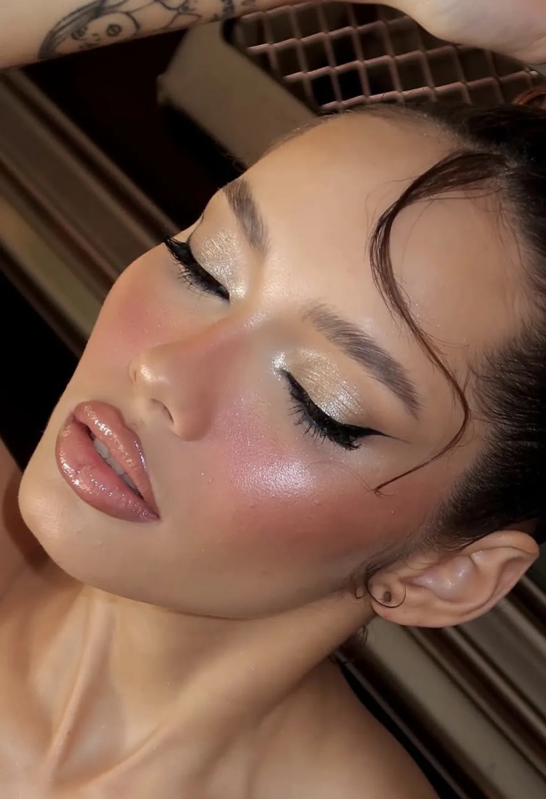 Close-up of a winged eyeliner with champagne shimmer on the lid and glowing skin