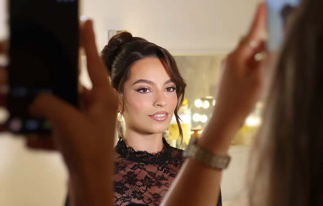Alunas a fotografar com o telemóvel a maquilhagem terminada da modelo, no fim de uma masterclass